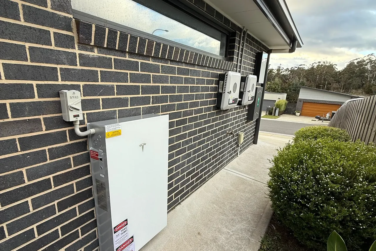 Home battery and solar inverters mounted on the wall of a Tasmanian house