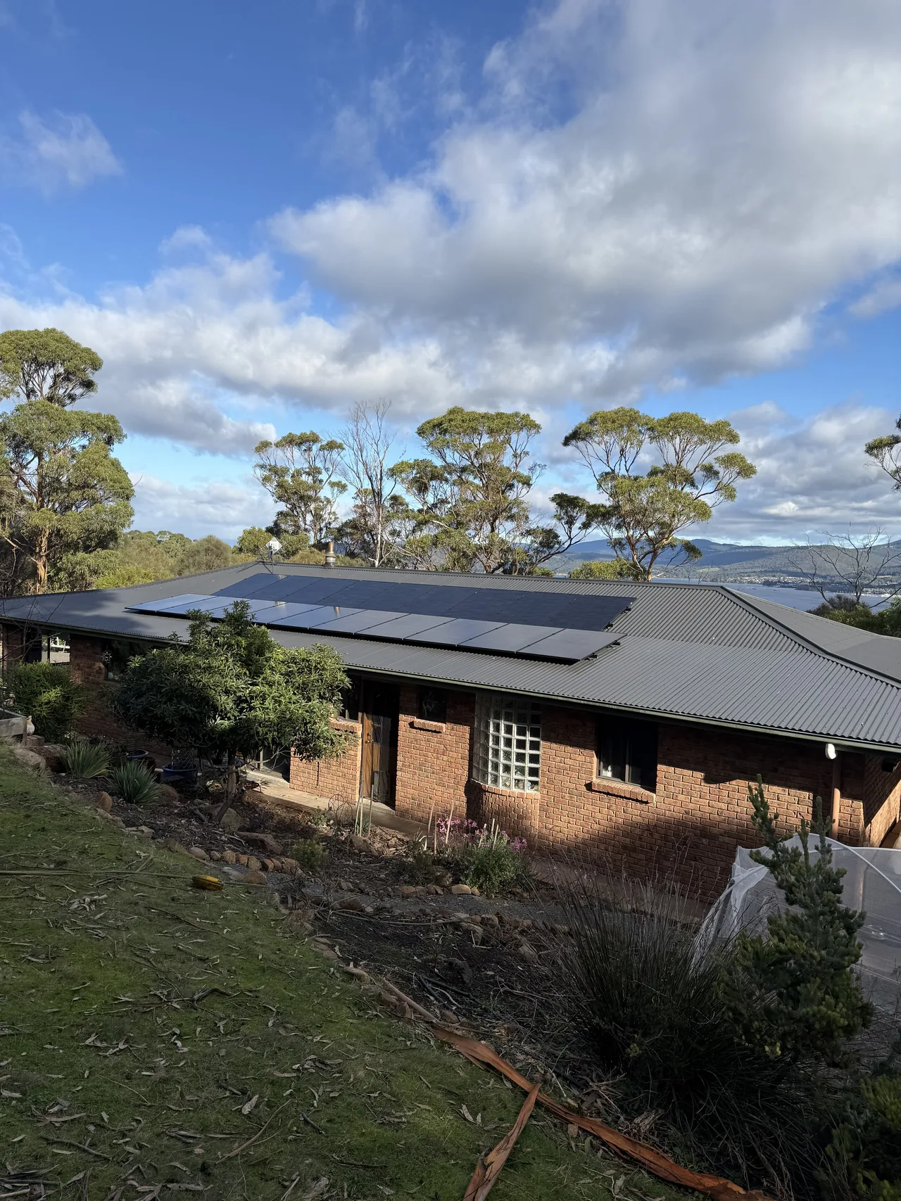 Solar panels along the roof of a Blackmans Bay home among the gums
