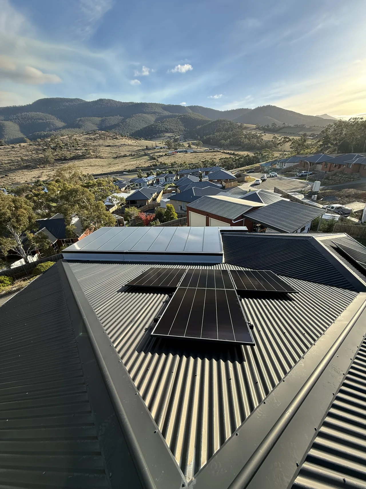 Panels across two roof planes with the mountains behind
