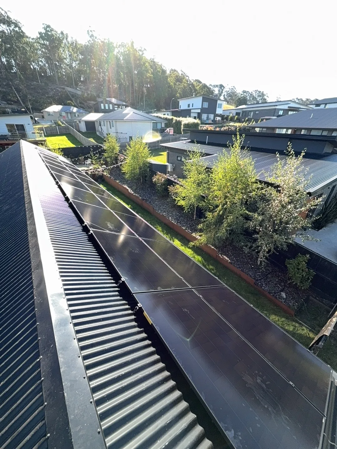The completed array along the roof under a clear sky