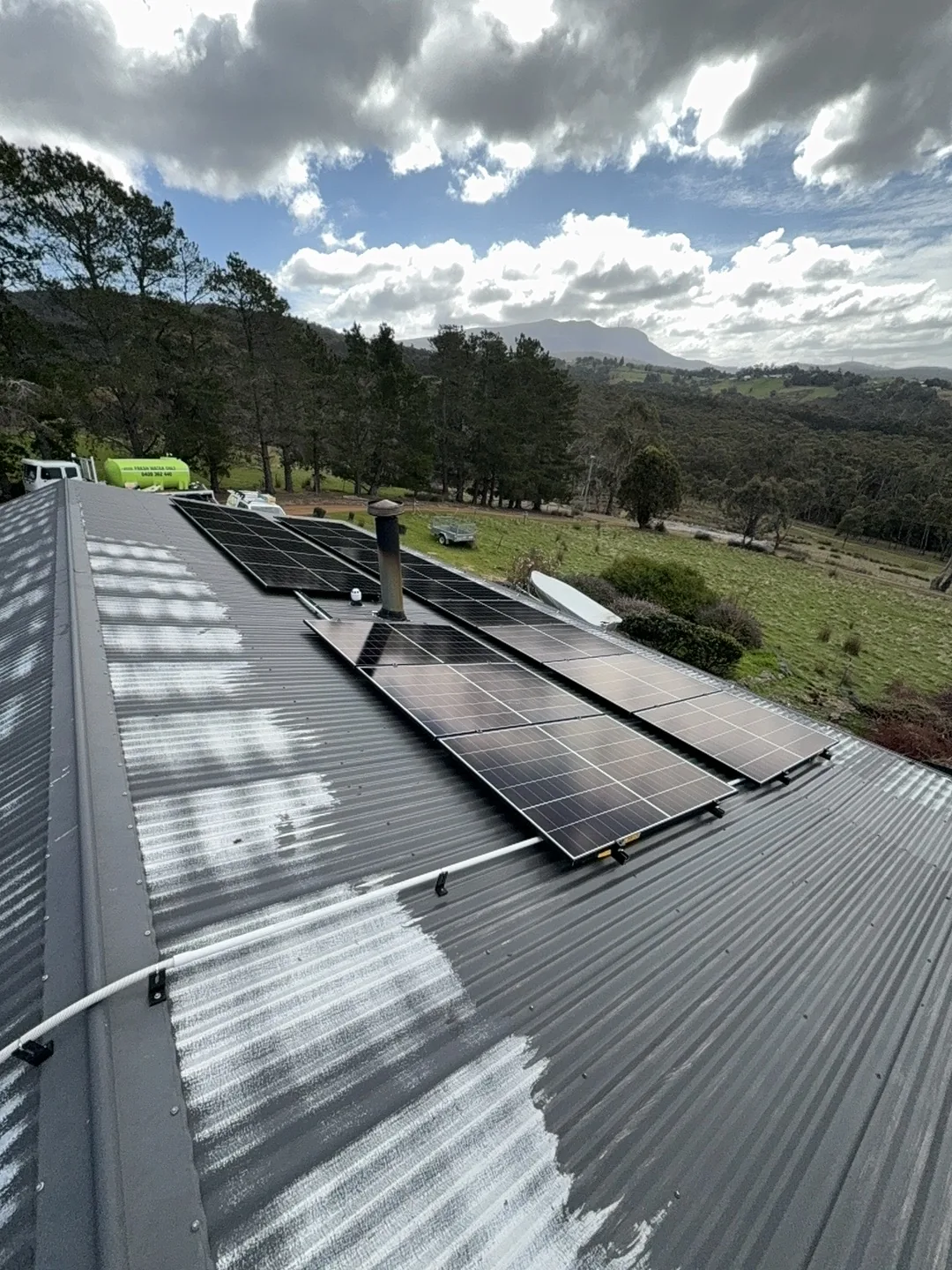 Panels on the roof with hills in the distance