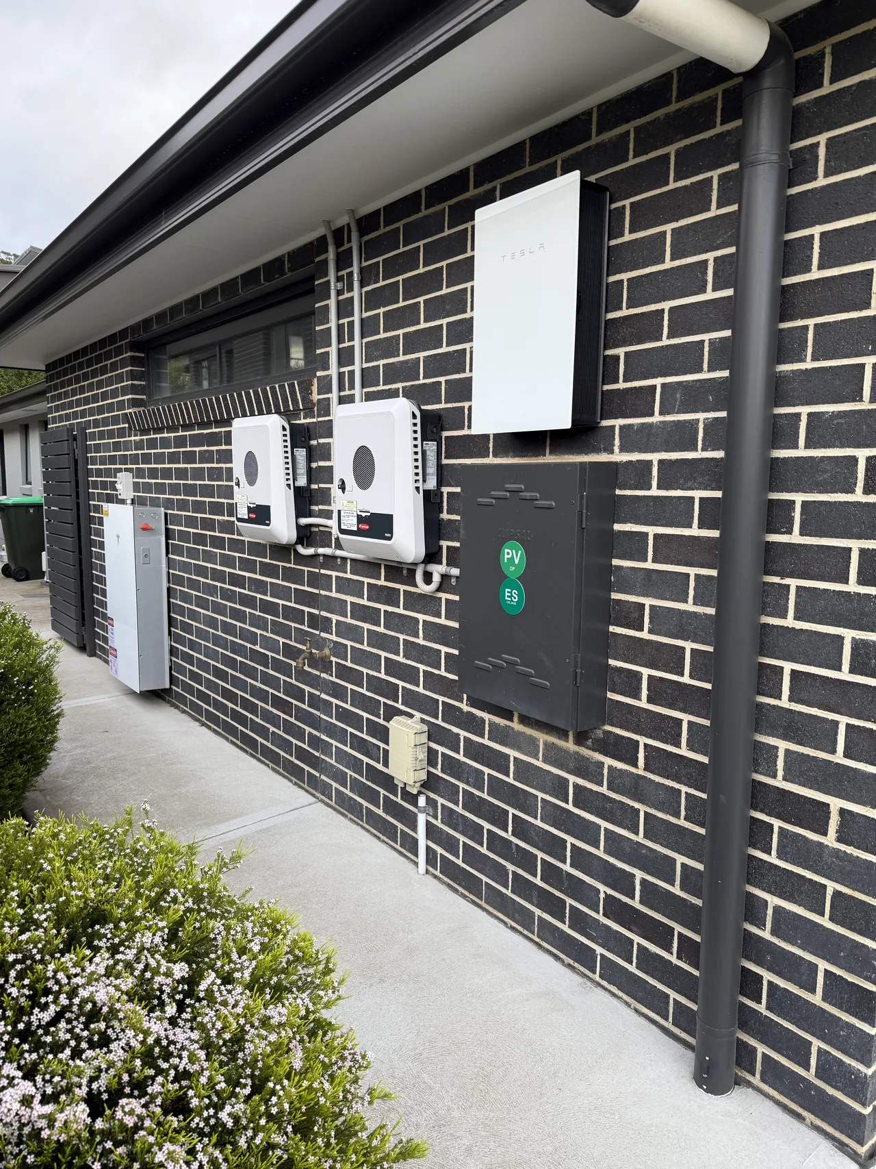 Tesla Powerwall 3 and backup gateway mounted alongside two existing Fronius inverters
