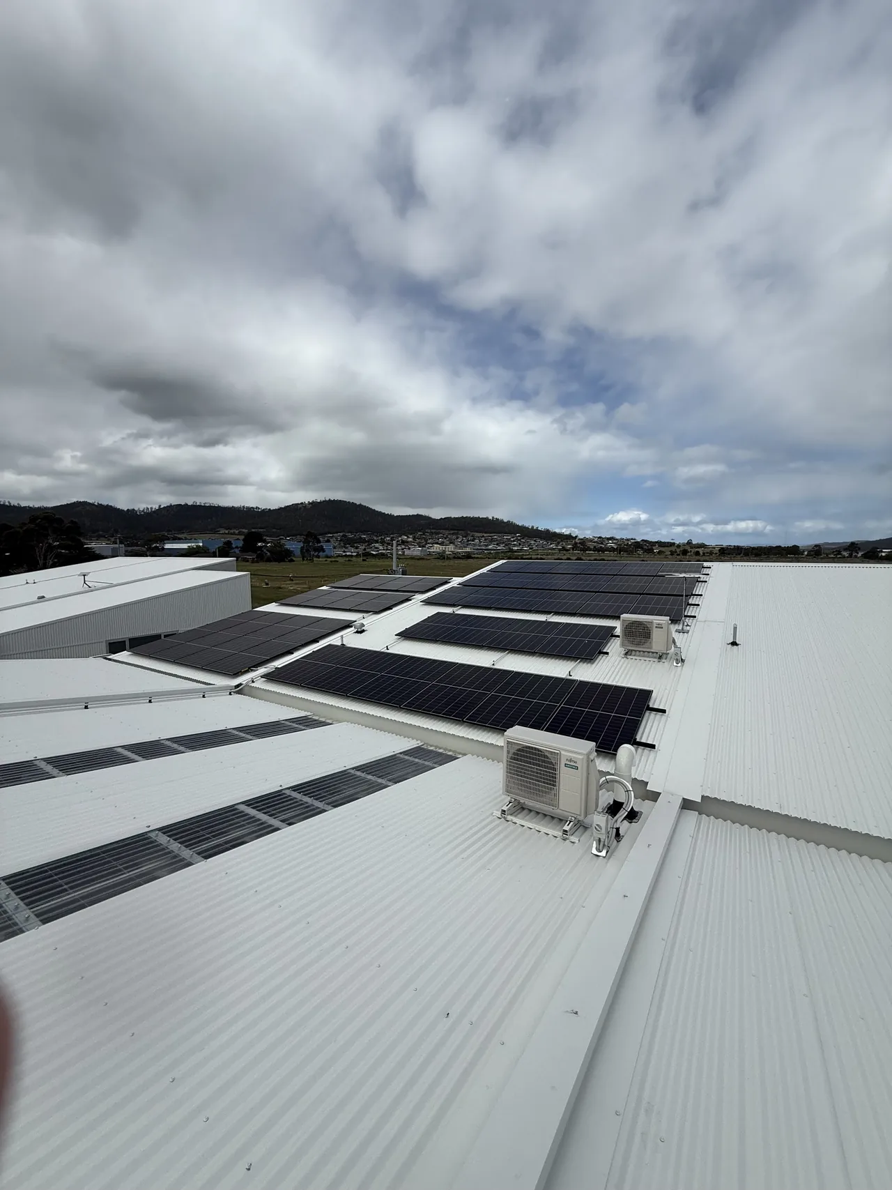 The array across the roof with plant and the hills beyond